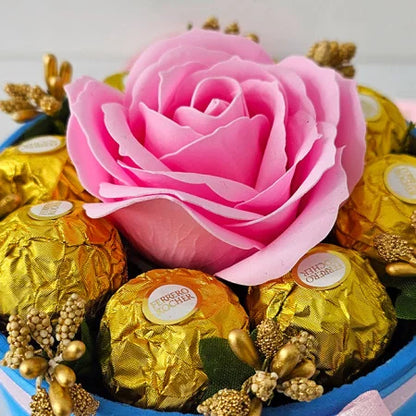 ARRANGEMENT FLORAL AVEC UNE ROSE SAVON, ÉTAMINES DORÉES ET 8 Ferrero Rocher, BOÎTE BLEUE, ROSE