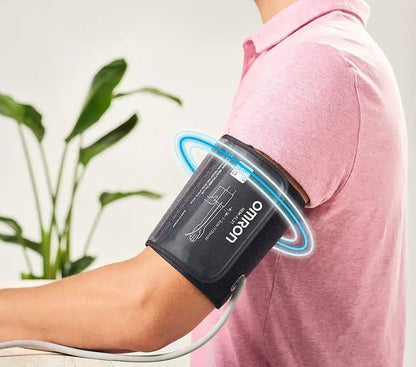 Person using Omron M4 Intelli IT digital blood pressure monitor with Intelli Wrap Cuff for accurate readings.